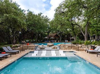Resort style pool with sun shelf and lounge seating